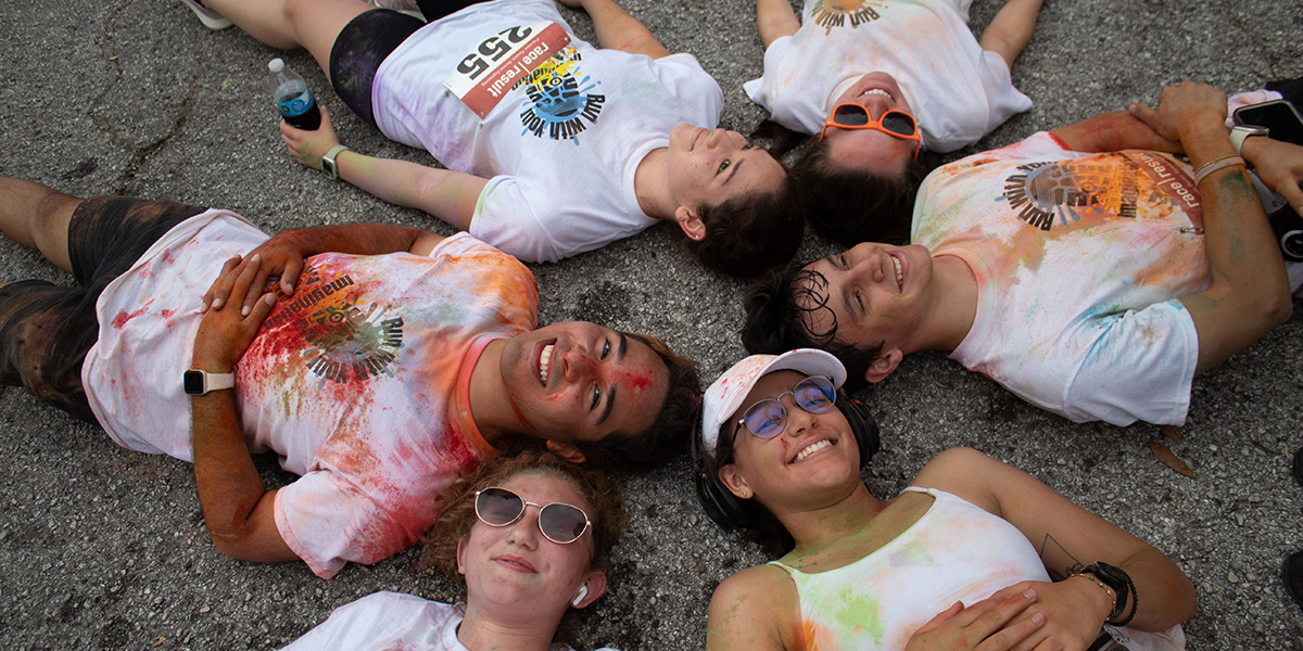 Students laying on ground in a circle